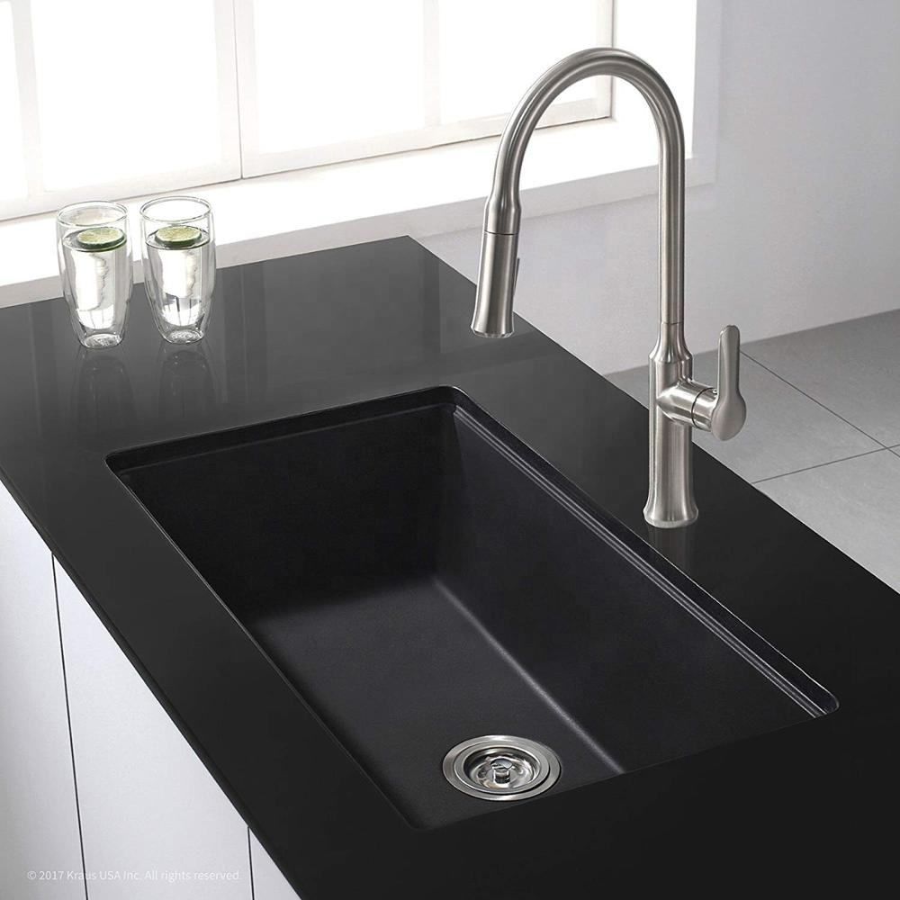 Black kitchen sink with a silver faucet in a modern kitchen setting.